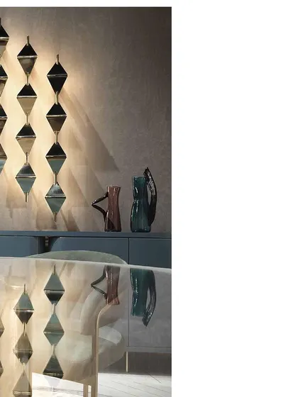 The reflection of the geometric wall light in the glossy dining table demonstrates how we consider every angle and surface in our lighting design. The result is a layered and visually rich environment.