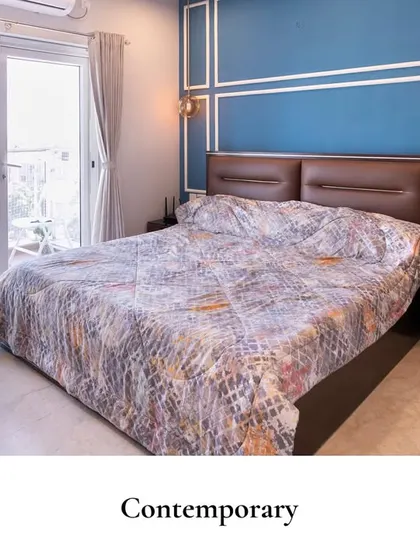 Minimal design, maximum impact. This contemporary bedroom uses a bold blue accent wall with decorative molding to create a sophisticated focal point. The simple furniture and ample natural light prove that less can be more.