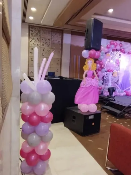 Balloon columns with Barbie cutouts are a great way to extend the theme throughout the party space, even next to the DJ setup.