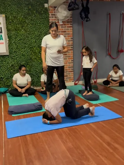 A student practices the entry into Sirsasana (Headstand) with my careful supervision.