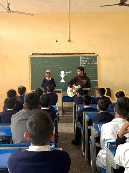 A student stands confidently at the front of the class to participate in a musical activity. Our sessions are designed to provide a platform for every child to step up and shine.