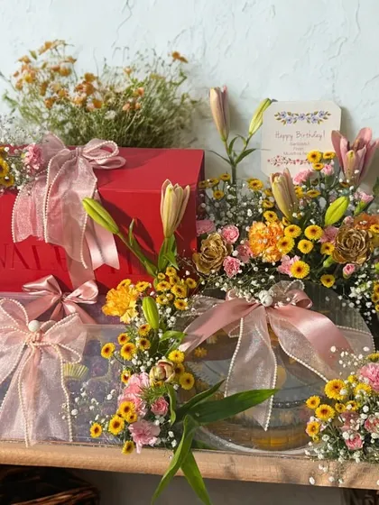 The full view of our stunning floral and gift arrangement, beautifully styled on a wooden shelf. This shows how our hampers can serve as a magnificent centerpiece for any celebration.
