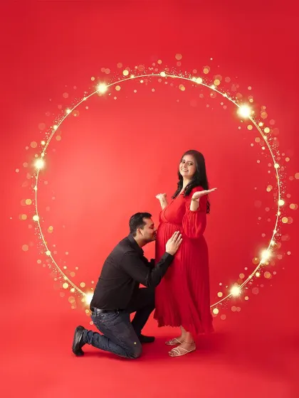 A magical moment created with special effects. The dad-to-be kisses the baby bump, surrounded by a circle of golden light, adding a touch of fantasy to the portrait.