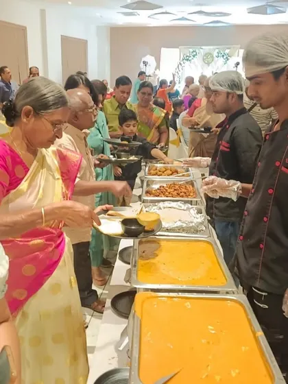 Our staff serving guests with a smile at a wedding anniversary party, ensuring a pleasant and memorable experience for everyone.