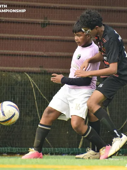 A tense moment as two players challenge for a loose ball near the sideline.