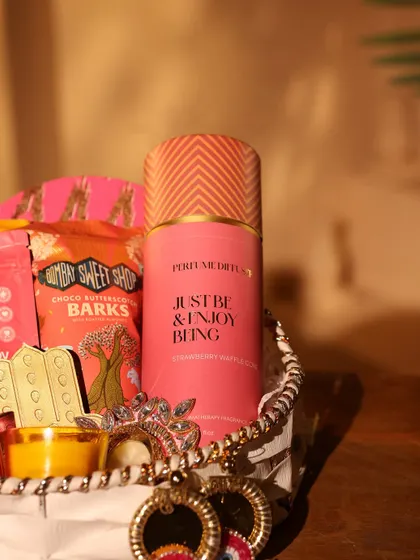A close-up on the stylishly packaged perfume and evil-eye jewelry, showcasing the trendy items I include in my festive hampers.