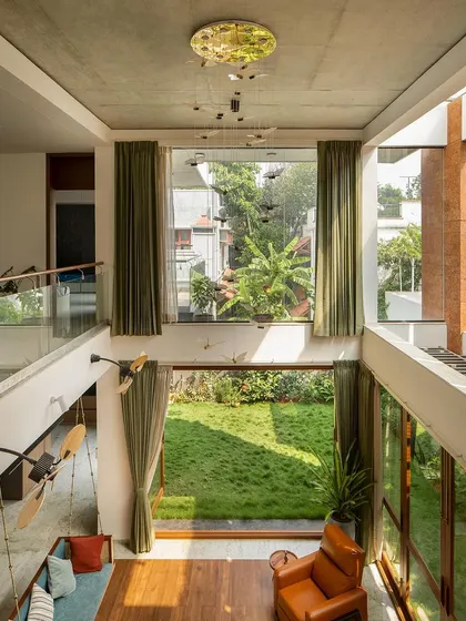A view from the upper-level family area вниз into the living pavilion. This visual connection between floors creates a sense of openness and ensures that the garden is a constant presence throughout the home.