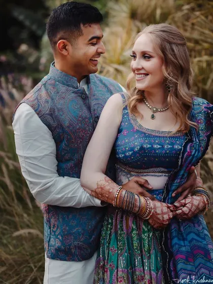 A happy couple portrait, where the bride's stained henna is a beautiful part of her festive look.
