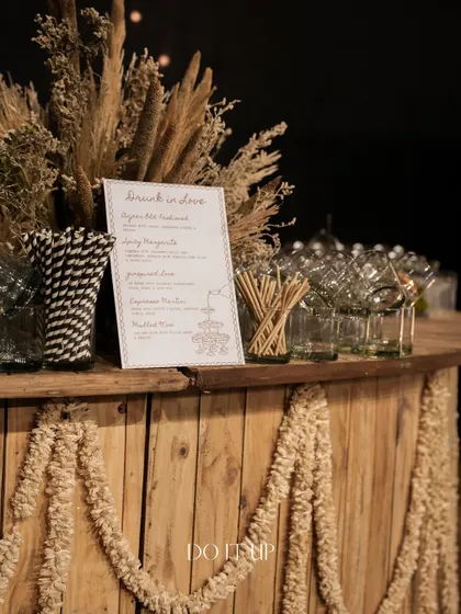 The bar was designed with a rustic wooden finish and decorated with jute tassels. The custom 'Drunk in Love' cocktail menu added a fun, personal touch to the evening.