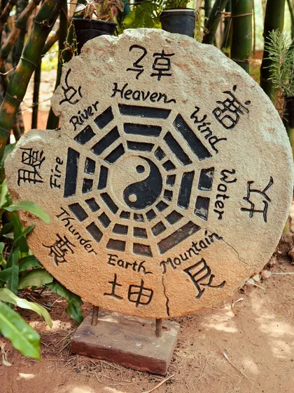 A stone carving of the elements, including Heaven, Wind, Water, and Earth, reflecting our natural ethos.
