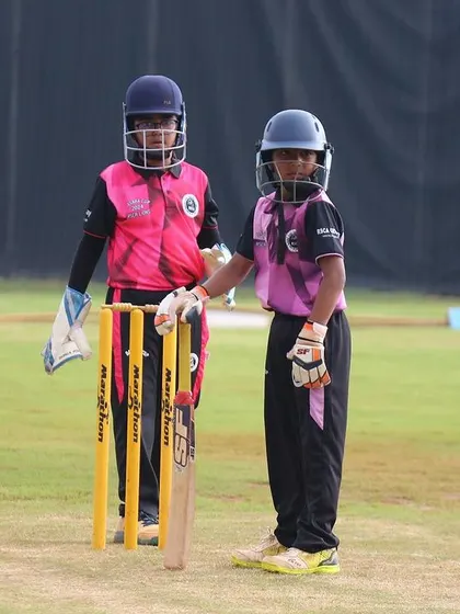 A young batter and wicketkeeper ready for action, showcasing the equipment and readiness of our junior players.