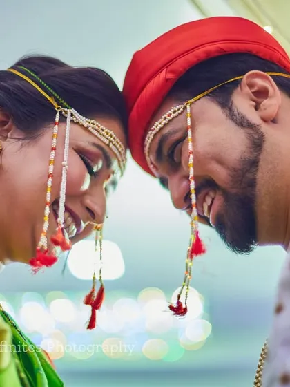 An intimate and joyful close-up. This photo highlights their happy expressions and the traditional details of their Maharashtrian wedding attire.