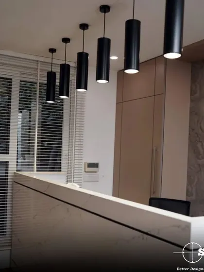 A sleek reception desk with marble-finish front and minimalist pendant lighting. This area is designed to be the first point of contact, communicating professionalism and modern design sensibilities.