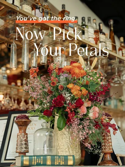 "You've got the ring, now pick your petals." A beautiful floral arrangement at a bar, reminding couples that after the proposal, the fun of designing their dream day begins.