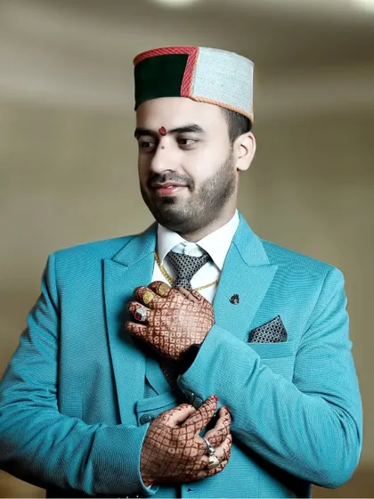 A stylish pose showing the groom's full attire. The focus on his hands, adorned with rings and henna, adds a layer of detail to the portrait.