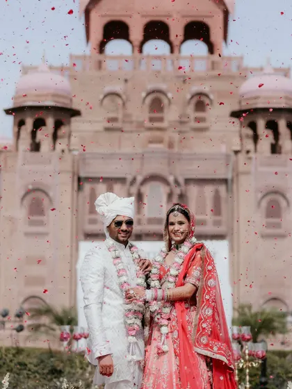 A moment of pure celebration. We live for these unscripted showers of joy, capturing the energy of your big day as you stand together against the magnificent backdrop of the Laxmi Niwas Palace.