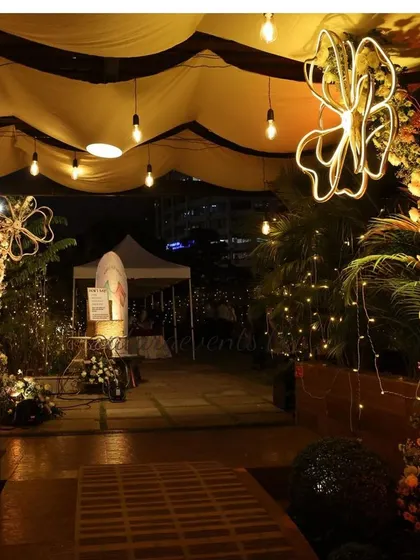 A nighttime view of the floral baby shower decor. The hanging lights and illuminated flower props create a magical and enchanting atmosphere for the celebration.