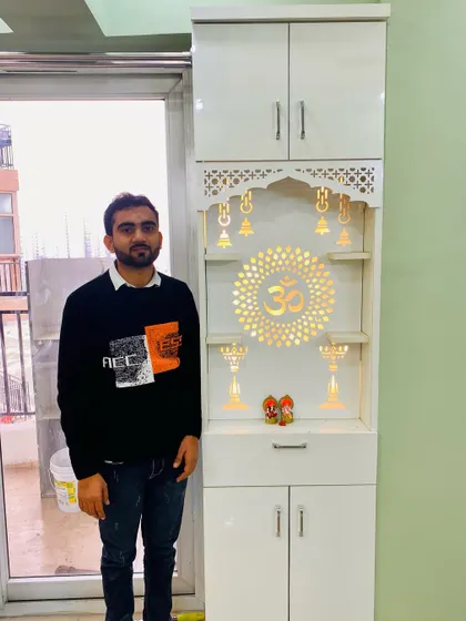 Presenting a finished pooja unit in a high-gloss white finish. The backlit jali panel with the "Om" symbol creates a serene ambiance.