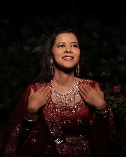 A joyful nighttime portrait of a bride, her face lit up with happiness as she admires her diamond necklace.