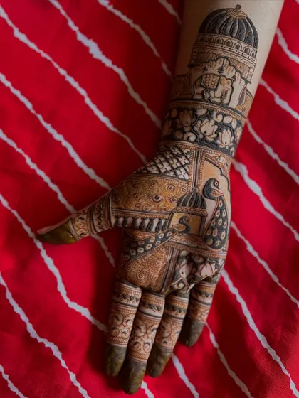 A still image of the Rajasthani-inspired bridal mehendi, showing the rich, dark stain against a vibrant red background.