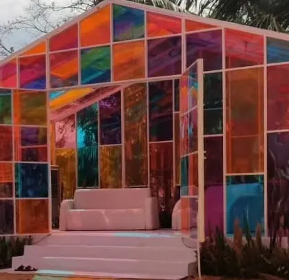 A unique "glass house" structure made with multi-colored translucent panels, creating a beautiful stained-glass effect for a modern and playful event space.