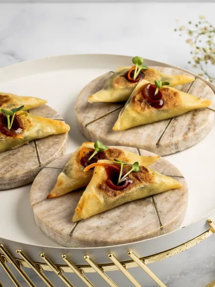 Our Spinach & Shiitake Samosettes are a modern twist on a classic. These crispy, triangular pastries are drizzled with a rich balsamic-soy reduction for an irresistible flavour.