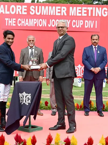 Jockey P. Trevor receives The Champion Jockey Cup Div I from Mr. Akshay Kumar, recognizing his exceptional skill on the track.
