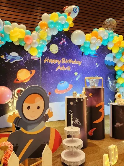 An out-of-this-world space and astronaut theme for a 3rd birthday. The galaxy backdrop, planet-themed balloons, and astronaut cutouts create an adventure in outer space.