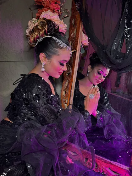 A reflective and artistic shot of the black-on-black party look, creating a moody and glamorous atmosphere.