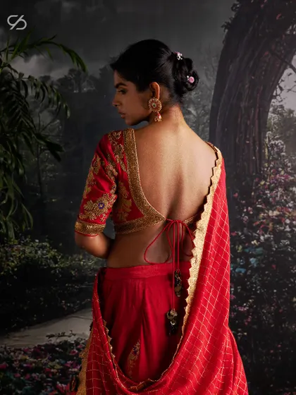 The back of this bridal blouse features a deep, elegant cut with traditional tassels, ensuring a stunning view as you walk down the aisle. Every detail is considered to create your perfect look.