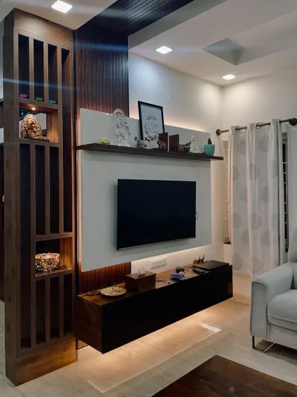 This living room features a floating TV unit with backlighting, creating a modern and clean look. The wooden partition adds warmth and texture, separating the space without closing it off.