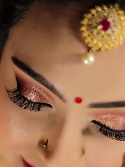 A detailed shot of Swathi's glamorous reception eye makeup. The combination of rose gold shimmer and dramatic lashes creates a truly captivating look.