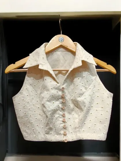 Elevate your saree style with this unique collared halter blouse. It's a modern, trendy cut crafted from delicate chikankari fabric, designed to complement and enhance the beauty of any saree.