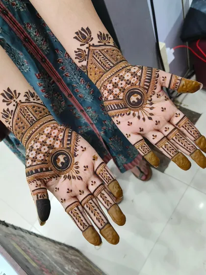 This is a beautiful example of Rajasthani-style bridal mehndi, featuring elephant motifs in the center of the palms. The rest of the design is filled with fine lines and traditional patterns.
