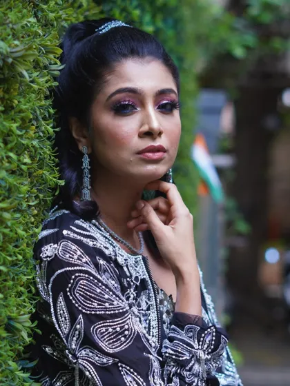 A confident and poised look against a green backdrop. The makeup is strong and defined, perfect for a woman who wants to command attention at any event.