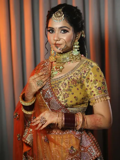 A beautiful bridal portrait in a mustard and red lehenga. I used warm, earthy tones for her makeup to complement the unique color of her outfit, creating a harmonious and elegant look.