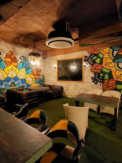 The cozy interior of Stegi, where we painted vibrant, colorful mandala art on multiple walls to create a warm and inviting atmosphere.