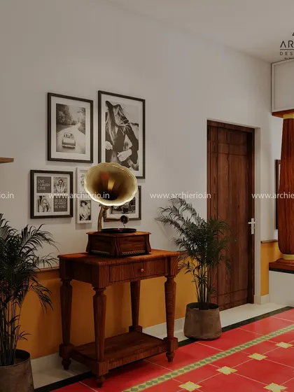 A corner that speaks of heritage, with a vintage gramophone and a gallery wall of black-and-white photos. The red oxide flooring and wooden pillar add to the traditional South Indian charm.