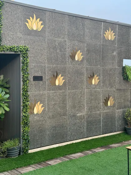 This image shows a unique wall treatment where we've added gold lotus embellishments to dark stone tiles. A vertical green border frames the entrance, blending artistic detail with nature.