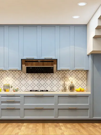 This kitchen showcases a classic shaker-style design in a calming powder blue. The patterned tile backsplash adds a touch of personality, while the wooden flooring brings warmth to the space.