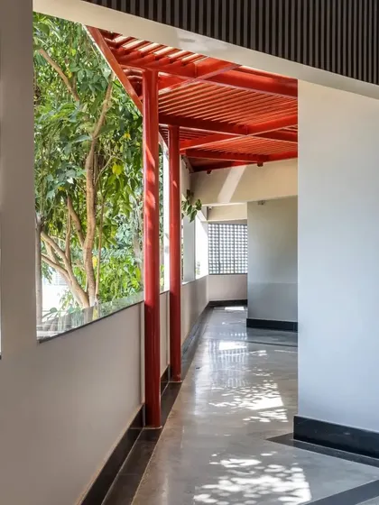 Light filters through the trees and into the semi-outdoor corridor at L'Atelier, creating a serene and inspiring atmosphere for students.