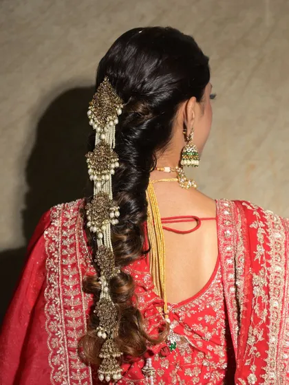 For this look, I used a statement piece of traditional jewelry to adorn the braid, creating a regal and eye-catching effect.