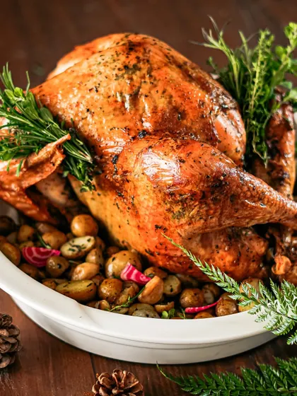 Our roasted turkey, garnished with an abundance of fresh rosemary and served on a bed of roasted baby potatoes. A complete and impressive main course for any holiday table.