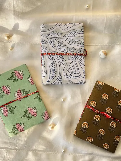This set of three journals features a mix of floral and leaf patterns in earthy tones of green and brown.