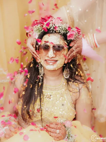 The bride gets her face covered in haldi by her loved ones. These rituals are full of laughter and make for great candid photos.