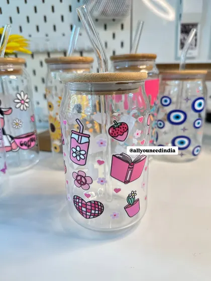 This pink-themed glass sipper is decorated with cute stickers like books, strawberries, and hearts.