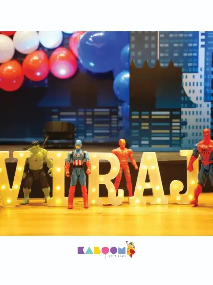 It's all in the details. We use light-up letters and character figurines to personalize the main table for the birthday hero at our Avengers-themed parties.