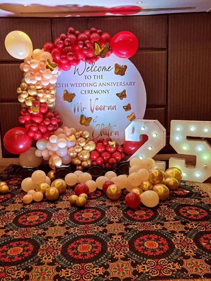 Celebrating a 25th wedding anniversary with a custom backdrop and marquee numbers. The red, gold, and cream balloon arrangement adds a touch of elegance, perfect for marking such a significant milestone.