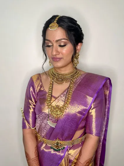 This image showcases the intricate details of a South Indian bridal look. The braided hair, flawless glam, and timeless elegance come together for a truly breathtaking result.