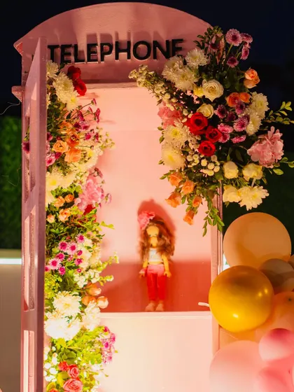 A beautiful telephone booth prop filled with flowers, a romantic and whimsical detail.